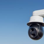 AXIS Q6411-LE Bispectral Video Camera mounted on a pole outdoors during the daylight hours.
